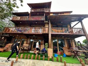 a man walking in front of a tree house at Floor river view in Cat Tien