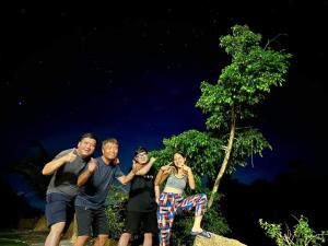 a group of people posing for a picture at night at Floor river view in Cat Tien