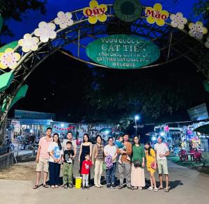a group of people posing for a picture in front of a gate at Floor river view in Cat Tien