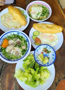 a table with plates of food and bread and vegetables at Floor river view in Cat Tien