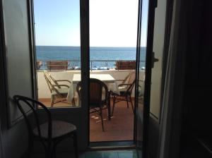 uma vista para o oceano a partir de um quarto com uma mesa e cadeiras em Hotel Lidomare em Amalfi