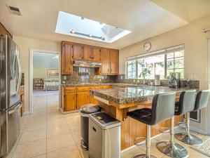 a kitchen with wooden cabinets and a island with bar stools at Amazing Santa Cruz Landscaped Paradise in Santa Cruz