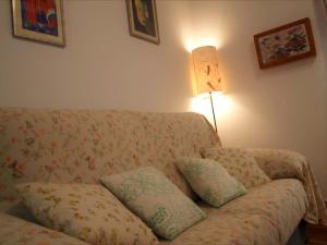 uma sala de estar com um sofá com almofadas e um candeeiro em La Casita de Nerea 2 Párking Gratuito em Cuenca