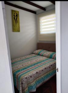 1 cama en un dormitorio con una foto en la pared en La Casa Blanca Departamento 2 en Coquimbo