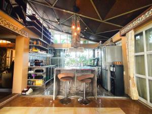 a kitchen with a counter with two stools at The Panorama Penthouse Daraga in Daraga
