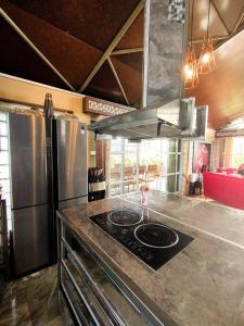 eine Küche mit einer Theke mit einem Herd und einem Kühlschrank in der Unterkunft The Panorama Penthouse Daraga in Locsin