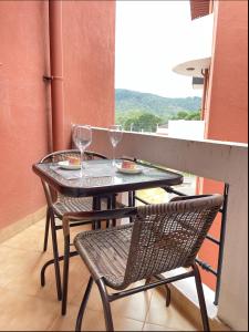 a table and chairs with wine glasses on a balcony at Breeze Holiday Casa in Nuwara Eliya