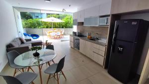 kuchnia ze szklanym stołem i czarną lodówką w obiekcie Apartamento de 3 dormitorios - San Bartolo w mieście Lima