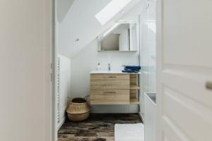ein weißes Badezimmer mit einem Waschbecken und einem Spiegel in der Unterkunft la bohème in Cherbourg en Cotentin