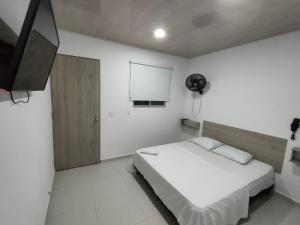 HOTEL MAR DEL CARIBE في Soledad: غرفة نوم بسرير وتلفزيون بشاشة مسطحة