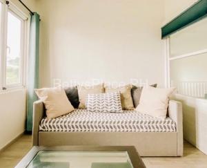a couch in a living room with a glass table at 4 Bedroom Beachfront House with Private Pool in Batangas in Nasugbu