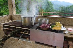 a grill with a pot and a plate of food at Alejandría, reserva natural y las 7 cascadas in La Vega
