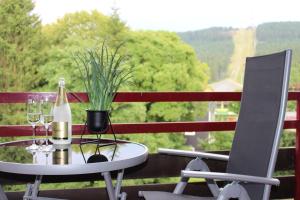 einen Tisch mit einer Flasche Wein und einem Stuhl in der Unterkunft Haus am See HS 470 B in Hahnenklee-Bockswiese