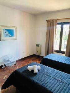 1 dormitorio con 2 camas con sábanas azules y ventana en Casa Los Perales en San Salvador de Jujuy