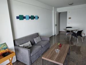 sala de estar con sofá y mesa en Vista sensacional frente mar, en Fortaleza