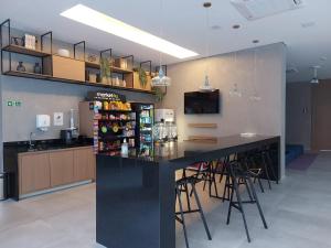 un bar en una cocina con encimera con taburetes en Lindo studio em Moema, en São Paulo