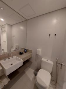 y baño con aseo blanco y lavamanos. en Lindo studio em Moema, en São Paulo