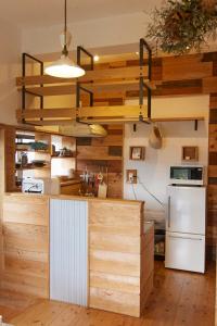 伊江村にあるプライベートハウス　ニヌファの木製の壁、白い冷蔵庫付きのキッチン