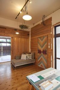 伊江村にあるプライベートハウス　ニヌファのソファ付きのリビングルーム、木製の壁