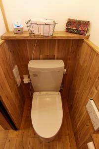 a toilet in a room with a wooden wall at Private House NINUFA in Ie