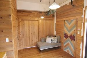 a sauna with a chair in a wooden wall at Private House NINUFA in Ie