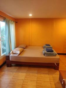 um quarto com uma cama com toalhas em นุชจนาถรีสอร์ท วังน้ำเขียว em Wang Nam Khieo