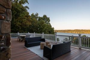 a deck with chairs and a table and a view of the water at River Haven with Hot Tub in Delta