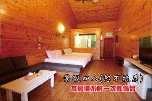 鹿谷的住宿－聽濤園山莊，一间卧室配有一张床、一张沙发和一台电视。