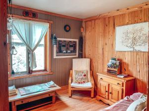 een slaapkamer met een stoel, een bureau en een raam bij Gîte B&B du Village in Saint Mathieu Du Parc