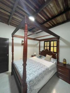 una camera con letto a baldacchino in legno di Amazon Lodge Varillal a Iquitos