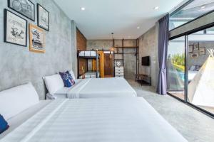 um quarto com 2 camas e uma grande janela em EL MAR Pool villa em Ban Bo Fai