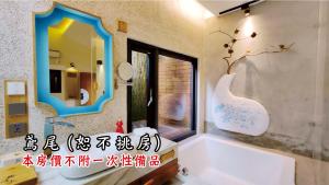 a bathroom with a tub and a mirror at Tingtau Villa in Lugu Lake