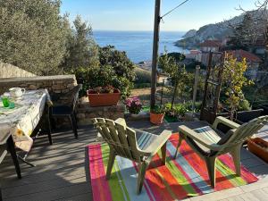a patio with a table and chairs and the ocean at Casa del sasso in Bergeggi
