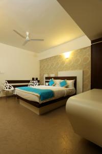 a bedroom with a king sized bed and a chair at moriz inn in Mysore