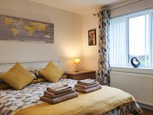 1 dormitorio con 1 cama con toallas en Seven Seasons en Caldercruix
