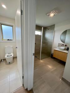 a bathroom with a toilet and a sink and a shower at Shell Cottage in Coles Bay