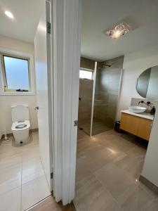 a bathroom with a toilet and a sink and a shower at Shell Cottage in Coles Bay +11 photos