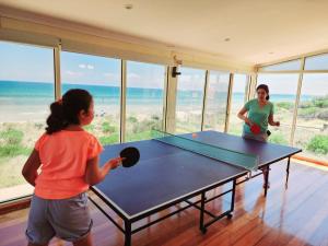 a woman and a girl playing a game of ping pong at Sandy Shores Estate- Long Island in Frankston