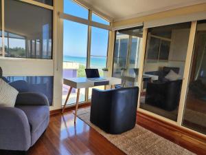 een woonkamer met een bank en een tafel en stoelen bij Sandy Shores Estate- Long Island in Frankston