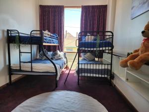 Zimmer mit 2 Etagenbetten und einem Fenster in der Unterkunft Sandy Shores Estate- Long Island in Frankston