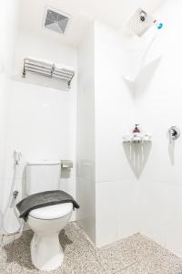 a white bathroom with a toilet with a towel on it at KIYANA HOTEL SEMARANG in Jomblang