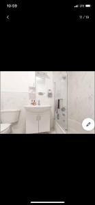 a white bathroom with a sink and a tub at Jersey city abode mins to city in Jersey City