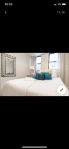 a bedroom with a large white bed with blue pillows at Jersey city abode mins to city in Jersey City