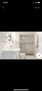 een witte badkamer met een wastafel en een toilet bij Jersey city abode mins to city in Jersey City