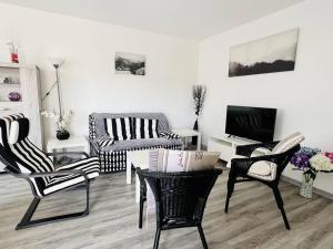 a living room with black and white chairs and a table at Appartement Cambo-les-Bains, 2 pièces, 2 personnes - FR-1-495-14 in Cambo-les-Bains