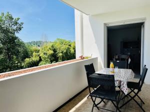 un tavolo e sedie su un balcone con vista di T2 à Cambo-Les-Bains, balcon, parking privé, près des thermes - FR-1-495-14 a Cambo-les-Bains