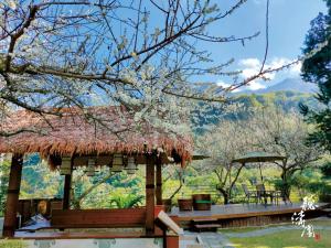 a pavilion with a grass roof and a picnic table at Tingtau Villa in Lugu Lake