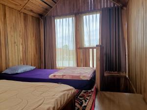 a small bedroom with two beds and a window at ADK Papandayan Homestay & Tour in Tjisurupan