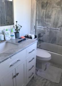 Un baño con lavabo, inodoro y ducha. en Shabby chic abode in Los Angeles ca, en Lomita 11 fotos más