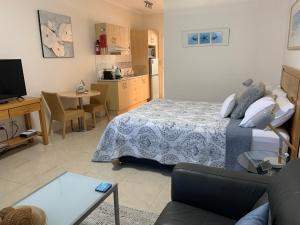 a bedroom with a bed and a living room at Pelicans Rest Shellharbour in Shellharbour
